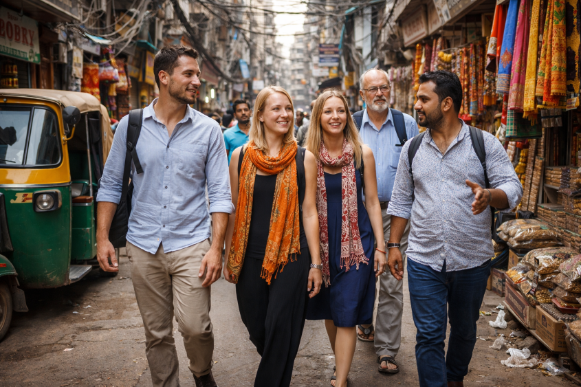 Foreign tourists exploring the vibrant lanes of Old Delhi with a local guide during a cultural heritage walk in India